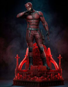 Daredevil action figure in a red suit stands on a red Gothic throne-like display, holding a baton.