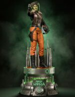 Hera Syndulla Star Wars action figure standing on a futuristic pedestal with a green glow and tall silver spires, holding a blaster.