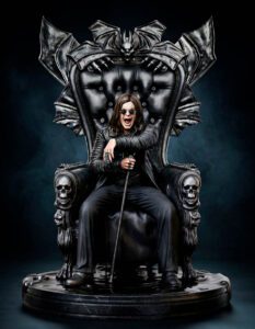 A person sits on a large black throne with bat-wing decorations and skulls on the armrests, holding a cane and wearing sunglasses.